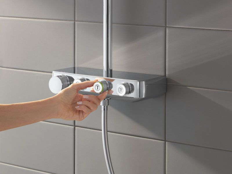 GROHE Smartcontrol Bedienelement. Eine Person dreht den Knopf um die Wassermenge einzustellen.